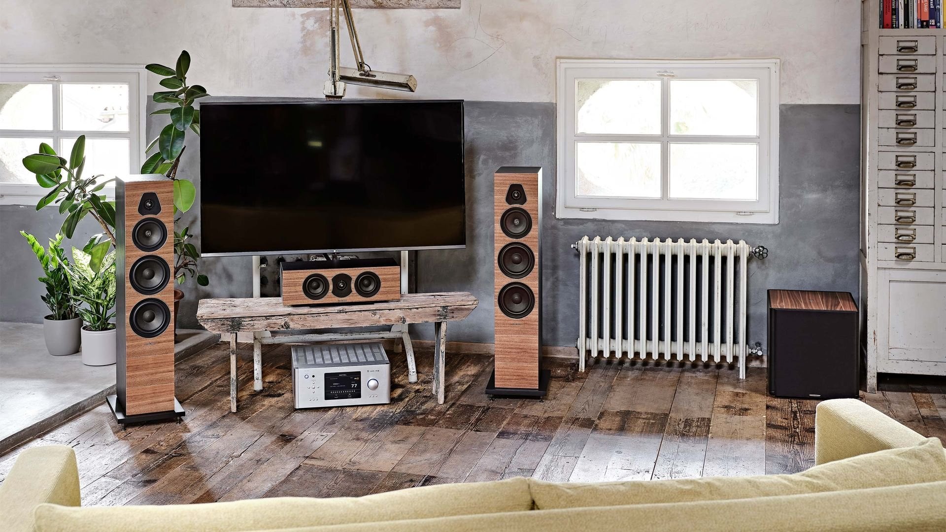 Сабвуфер Sonus faber Gravis III из орехового дерева, дополняющий колонки Olympica Nova в домашней аудиосистеме с телевизором.
