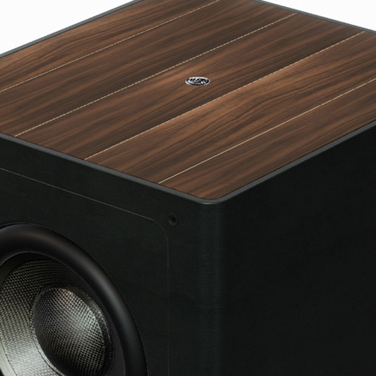 Крупный план верхней части сабвуфера Sonus faber Gravis III с отделкой из орехового дерева и черной кожи, демонстрирующий натуральные материалы.