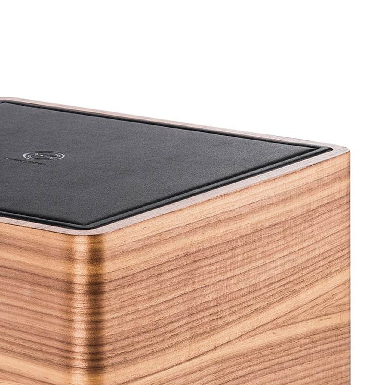 Крупный план сабвуфера Sonus faber Gravis I с отделкой из орехового дерева и черной кожи.